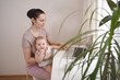 © Алина Троева - Young mother work studying from home with laptop computer during quarantine, little cute toddler baby on lap. Home office, parenthood. Remote work, distance education. Video conference virtual event.