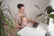 © Алина Троева - Young mother work studying from home with laptop computer during quarantine, little cute toddler baby on lap. Home office, parenthood. Remote work, distance education. Video conference virtual event.