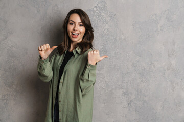 Sticker - Happy beautiful brunette girl smiling and pointing fingers aside