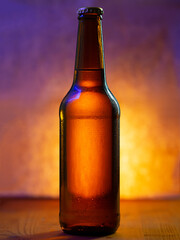 A bottle of cold beer in water drops on a yellow background with neon lighting