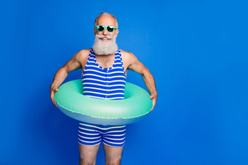 Sticker - Photo of optimistic grey beard man wear lifebuoy eyewear blue swimsuit isolated on blue background