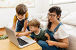 Kids using laptop with mother at home