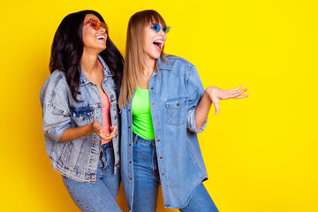 Canvas Print - Portrait of carefree funny girls look empty space laughing have good mood isolated on yellow color background