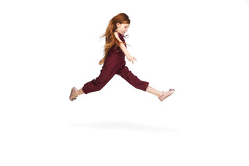 Wall Mural - Jumping, flying. Happy, smiley little caucasian girl isolated on white studio background with copyspace for ad. Looks happy, cheerful. Childhood, education, human emotions, facial expression concept.