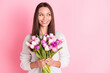 © deagreez - Photo of dreamy happy nice young woman look empty space hold flowers smile isolated on pastel pink color background