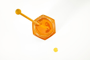 Sticker - Top view of a jar full of tasty honey with a wooden dipper isolated on a white surfac