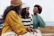 © Flamingo Images - Diverse women in sweaters laughing outside on a cold morning