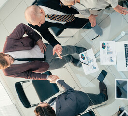 Poster - top view. business people shaking hands in the meeting room.