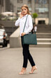 © Bogdan - Young beautiful blonde business lady in classic look walking on the street with Briefcase Designer Leather Laptop Satchel Portfolio Messenger Bag.  different color of bag and no logo