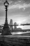 Fototapeta  - Czarno-białe pionowe ujęcie kładki dla pieszych Millenium Bridge w Londynie o zachodzie słońca