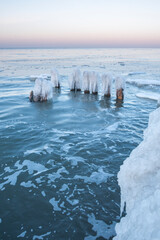 ice breakwaters, covered with snow, stand in the winter sea. sea winter landscape background.