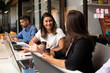 © Vergani Fotografia - brazilian woman talking causally with co-worker in workstation. .