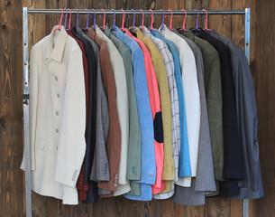 Canvas Print - a set of colored business suit jackets on a hanger in a wardrobe