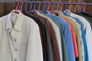 Canvas Print - a set of colored business suit jackets on a hanger in a wardrobe