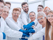 © ASDF - group of medical lab employees joining their palms together.