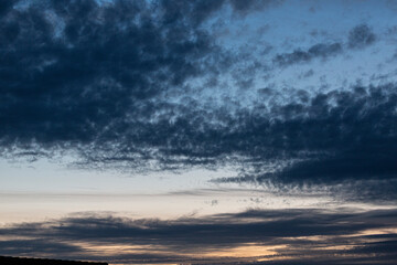 Wall Mural - Photo of cloudy sky at sunset with orange reddish sky