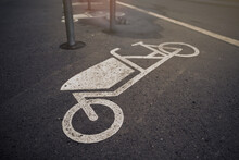 Close Up On Cargo Bike Symbol On Tarmac At An Urban Bicycle Parking Space In Sunny Bright Light Mood- Urban Mobility Concept With Selective Focus