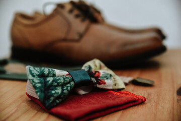 Canvas Print - Closeup shot of a colorful bow tie on a red handkerchief with brown shoes in the background