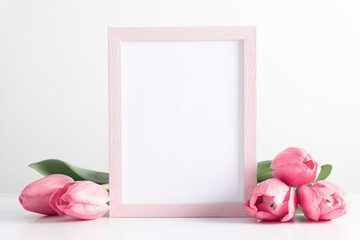 Wall Mural - flowers composition romantic. pink photo frame mockup with pink tulips, spring flowers on white tabl