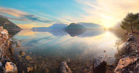 Wall Mural - sunset view from rocky shore of mountain lake