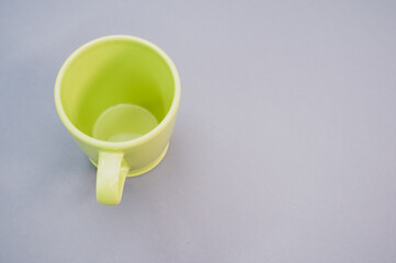 Poster - Empty green plastic cup isolated on a grey background