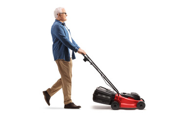 Full length profile shot of a mature man mawing with a lawnmower machine