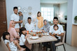 © Odua Images - portrait of big asian muslim family on iftar dinner together smiling and looking at camera