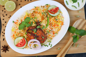 Wall Mural - Fish biryani , Spicy and delicious Malabar biryani or Hyderabadi biryani, Dum Biriyani, pulao Kerala India Sri Lanka . basmati rice, herbs, raitha for Ramadan Kareem, Eid