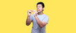 Asian man is eating fried chicken deliciously on Yellow background