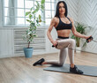 © Fxquadro - Graceful adult sportswoman in sportive clothing works out with a resistance bands in light room with windows on mat.