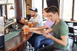 © Pixel-Shot - Young people placing sports bet in pub