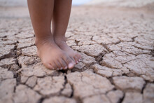 The Ground Was Dry And Cracked, With Little Boy's Feet Standing