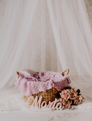 A basket for a newborn baby with dusty pink roses and a name of a baby