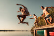 © Zoran Zeremski - Young friends having fun enjoying a summer day swimming and jumping at the lake.