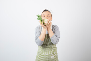 Wall Mural - Photo of a young nice woman model in apron holding a cauliflower