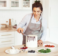 Pastry chef in the kitchen decorating a cake of chocolate