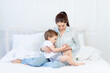 © Any Grant - mom and baby talking at home on the bed, the concept of the relationship between parents and children