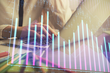 Double exposure of woman hands typing on computer and financial graph hologram drawing. Stock market analysis concept.