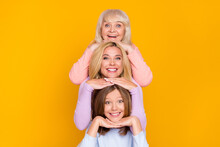 Photo Of Nice Optimistic Three Woman Grand Mom Daughter Hands Face Wear Pastel Cloth Isolated On Yellow Color Background