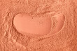 Red terracotta bentonite clay powder. Natural beauty treatment and spa. Clay texture close up, selective focus. Abstract background.