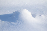 Fototapeta Na ścianę - White big snowdrift and in winter on a sunny day.