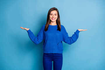 Sticker - Photo of young lovely pretty smiling happy positive girl hold hands in balance demonstrate offer isolated on blue color background