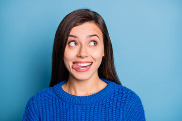 Sticker - Portrait of young happy smiling funky good mood girl look copyspace stick tongue out isolated on blue color background