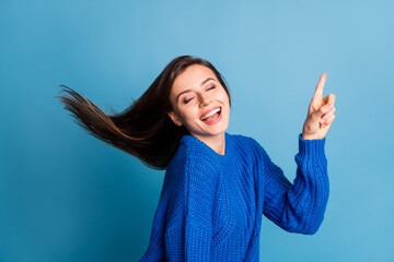 Poster - Photo of young beautiful smiling happy good mood girl pointing finger copyspace isolated on blue color background