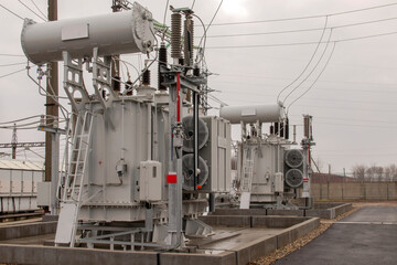 Electrical transformers: equipment used to step up or step down voltage, high voltage power plant. Side view.