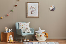 Cozy Interior Of Child Room With Mint Armchair, Brown Mock Up Poster Frame, Toys, Teddy Bear, Plush Animal, Decoration And Hanging Cotton Colorful Balls. Beige Wall. Warm Kid Space.  Template.