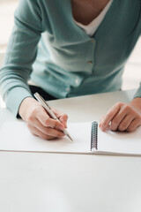 Wall Mural - Business women work on computers and write on notepad with pen to calculate financial statements within the office.