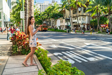 Waikiki Tourist Woman Walking In Honolulu City Street Using Mobile Phone. Hawaii Summer Vacation Destination.