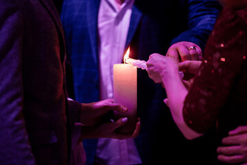 Wall Mural - Happy stylish wedding couple holding candles with fire and light them up with candle from parents, family fire tradition at reception. Bride and groom at holy matrimony