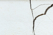 A House White Wall With A Large Crack. Grunge Concrete Cement White Wall With A Crack In An Industrial Building.